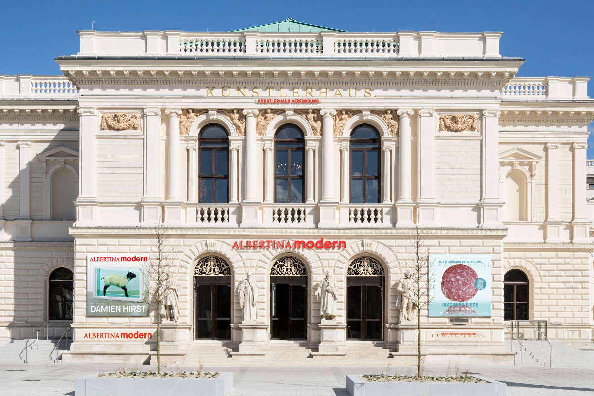 Frontalansicht des klassizistischen Gebäudes der ALBERTINA MODERN mit Statuen, Säulen und Ausstellungspostern © Rupert Steiner
