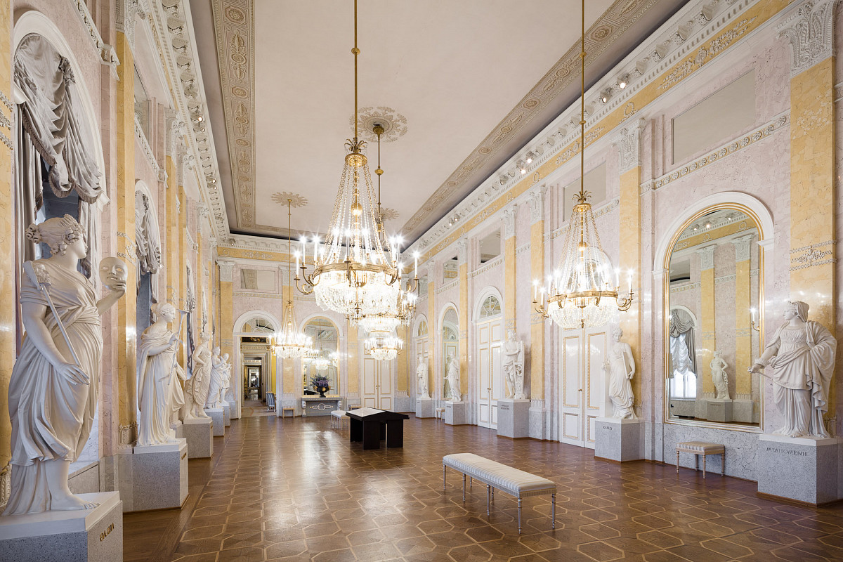 Der Musensaal der Albertina: Parkettholzboden, fünf Luster an der Decke und an den beiden langen Wänden stehen Statuen von Musen | Credit: Foto © Georg Molterer