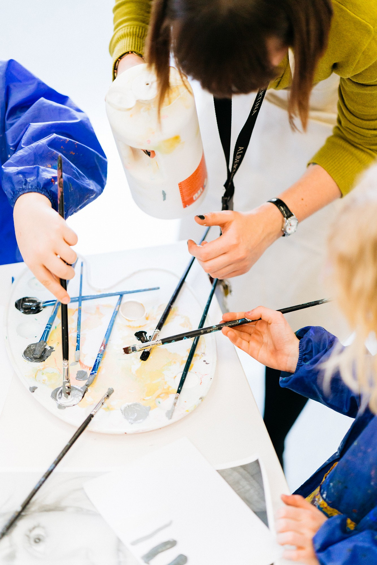 Kinder beim Malen mit Pinsel