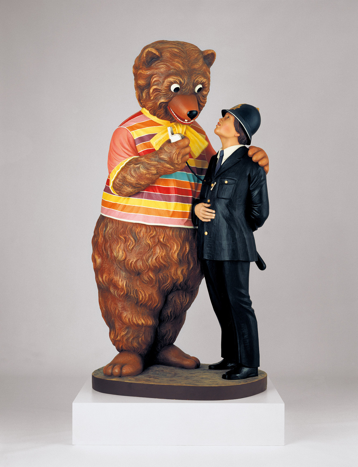 Skulptur eines freundlich wirkenden Bären, der ein T-Shirt trägt, und einen Arm um einen Polizisten in Uniform gelegt hat. | Jeff Koons | Bear and Policeman, 1988 | Kunstmuseum Wolfsburg © Jeff Koons | Foto: Gautier Deblonde
