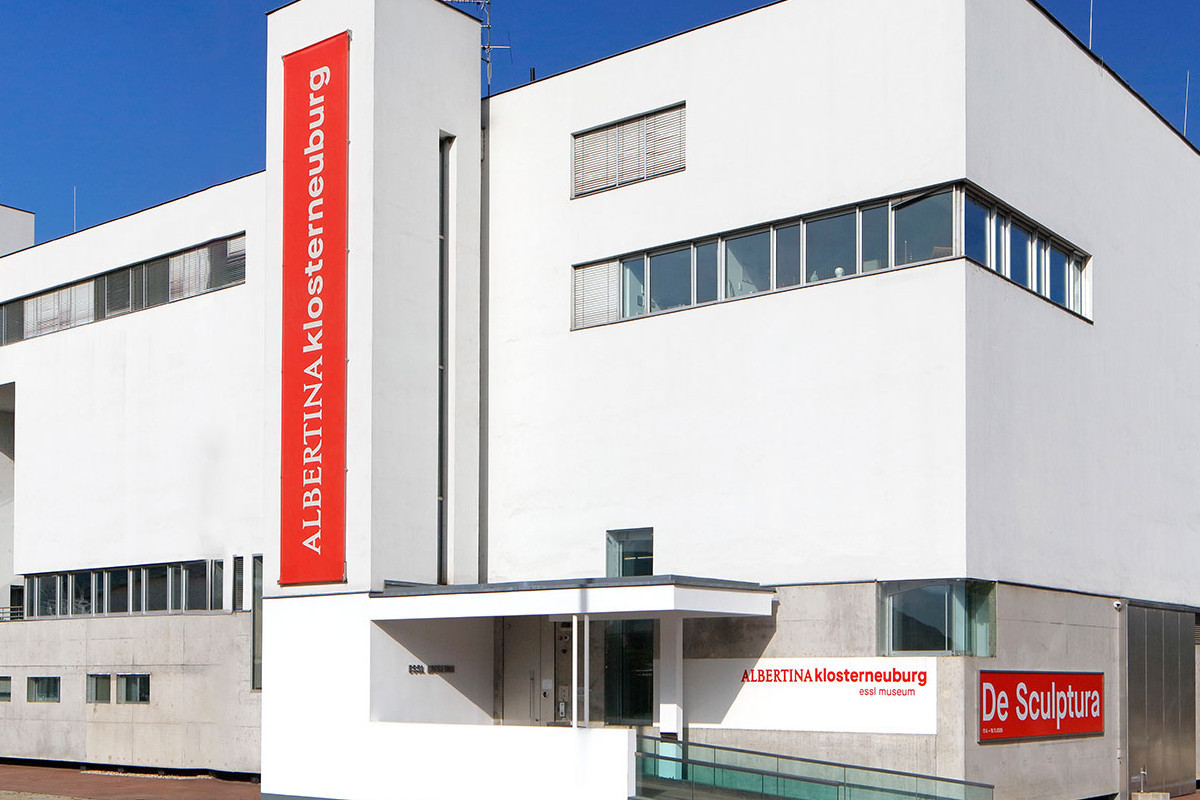 Weißes, modernes Gebäude von außen mit rotem Schriftzug ALBERTINA KLOSTERNEUBURG. Credit: Foto © Rainer Iglar