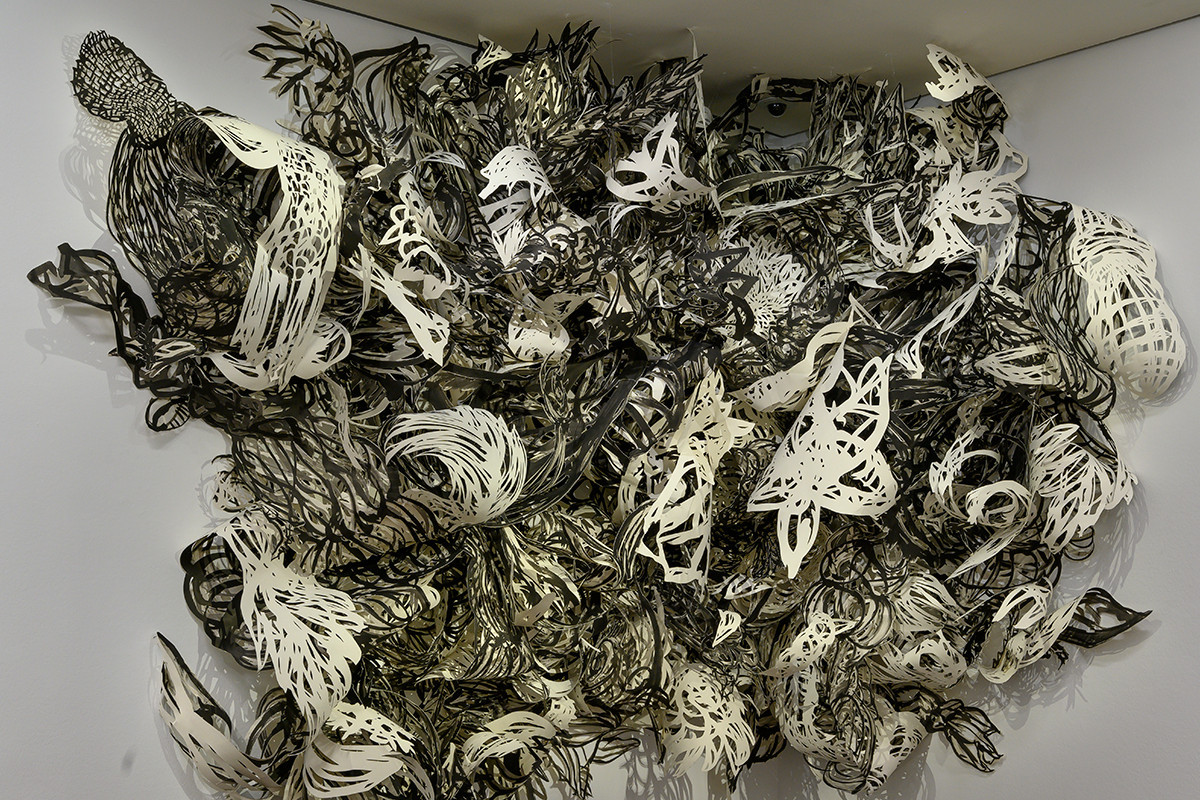 A corner of a room with a brown parquet floor and white wall. On the wall, in the corner, hangs a large installation of paper cut-outs in various patterns in black and white. Credit: Birgit Knoechl | out of control_revisited the autonomy of growth_0IV, 2006-2008/2012 | The ALBERTINA Museum, Vienna – Acquisition from gallery funding of BMUKK 2012 © Birgit Knoechl / Bildrecht, Vienna 2025