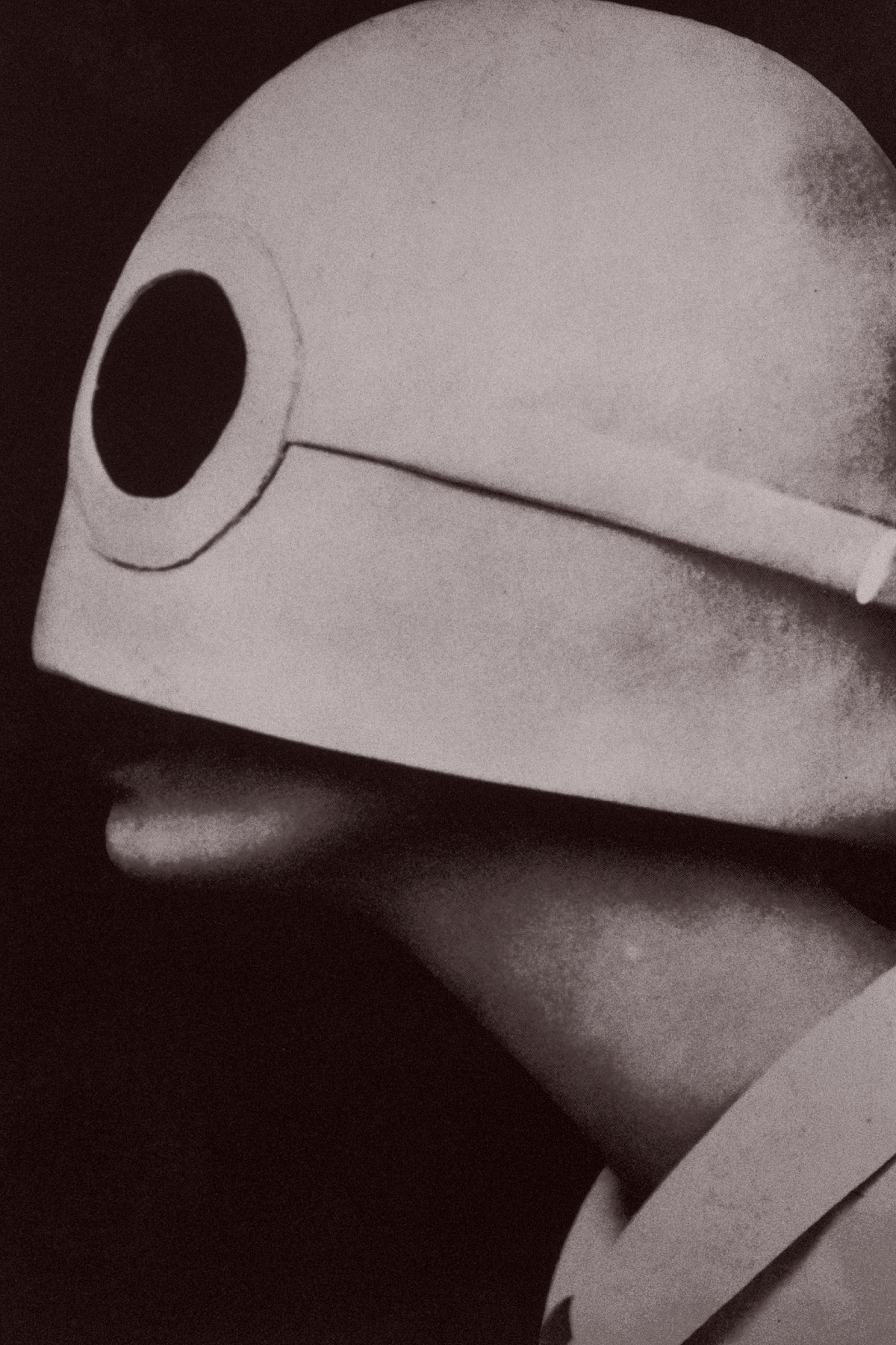 Ein Kopf im seitlichen Porträt mit einem großen Hut, der das ganze Gesicht bis kurz vor dem Mund bedeckt.