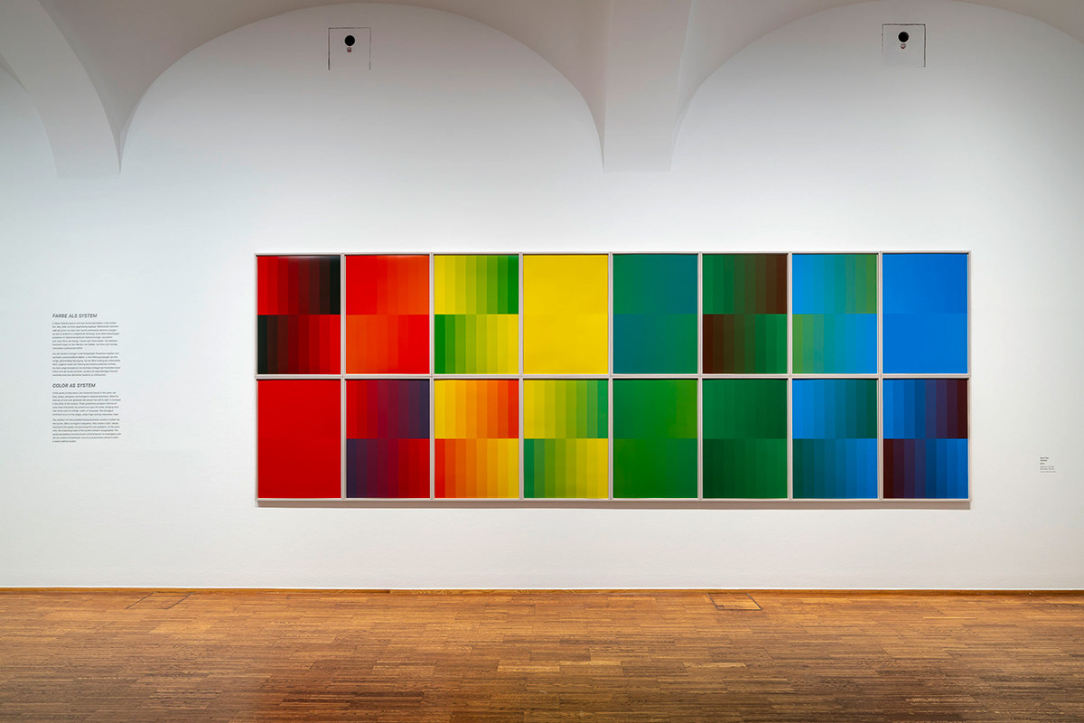 Exhibition view: 16-part abstract screen print by Helga Philipp with a serial, geometric composition.