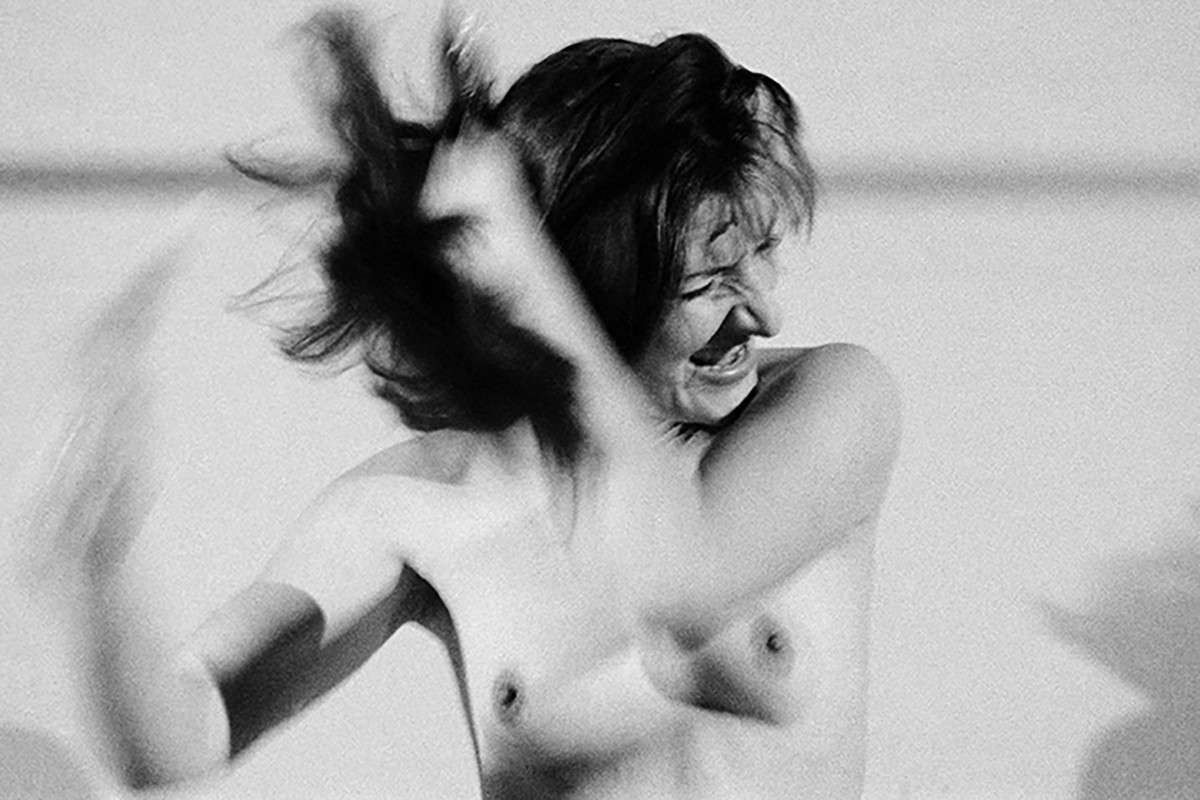 Die Künstlerin bürstet sich wild die Haare mit nacktem Oberkörper. Credit: Marina Abramović | Art must be beautiful / Artist must be beautiful, 1975/2025