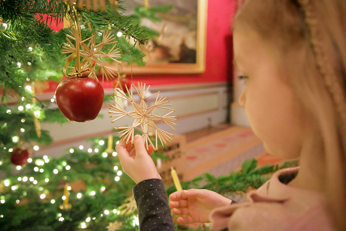 Kunst steht vor Christbaum und hält dessen Dekoration in der Hand | Foto © Georg Molterer
